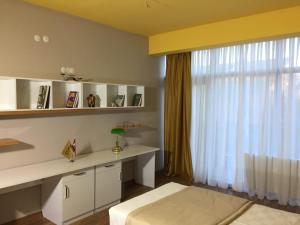 ein Schlafzimmer mit Schreibtisch und Fenster in der Unterkunft Dora Suit in Çankaya
