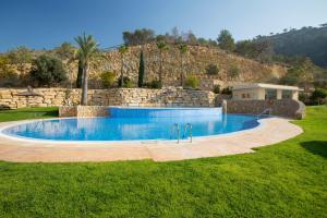 a swimming pool in a yard with a stone wall at Skyscraper apartment with panoramic views - floor 38 in Benidorm