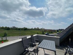 una terraza con sillas y una mesa en el techo en Auf Feiningers Spuren durch das Mönchgut Apartment 1, en Lobbe