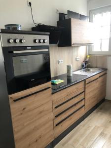 La cocina está equipada con fogones, horno y fregadero. en Auf Feiningers Spuren durch das Mönchgut Apartment 1, en Lobbe 5 fotos más