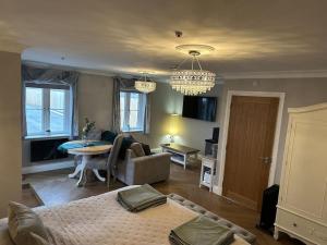 a living room with a bed and a dining room at Milestone Cottage in Swansea