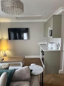 un soggiorno con divano e cucina di Milestone Cottage a Swansea