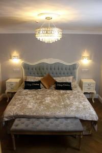 una camera da letto con un letto grande con testiera blu di Milestone Cottage a Swansea