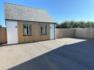 a garage with a fence and a building at Milestone Cottage in Swansea