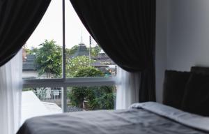 1 dormitorio con ventana con vistas a la ciudad en The One Apartment, en Rawai Beach