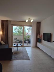 a living room with a couch and a tv at Sunset Penthouse in Gessate