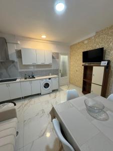 Una cocina con gabinetes blancos y una mesa con sillas. en Padre Mariana, en Alicante