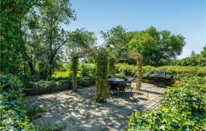 a garden with a table and a pergola at Nice Home In Spjald With 6 Bedrooms in Videbæk +28 photos