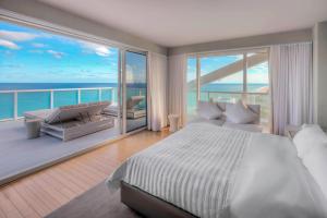 Un dormitorio con una cama y un balcón con vista al mar. en W Fort Lauderdale, en Fort Lauderdale 130 fotos más