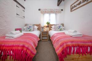 ein Zimmer mit zwei Betten mit Handtüchern darauf in der Unterkunft Daisy Cottage in Paignton