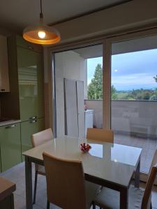 a kitchen and dining room with a white table and chairs at Sunset Penthouse in Gessate