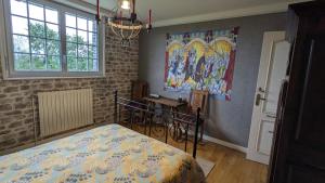 una camera da letto con un letto, un tavolo e un quadro di Les Chambres de KERCHELGEN a Saint-Sauveur