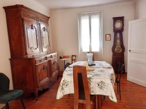 a dining room with a table and a large wooden cabinet at Les Sables d'Olonne - Arago - Le 16 in Les Sables-d'Olonne