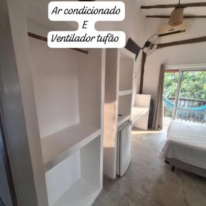 een slaapkamer met witte planken en een bed bij Alma Surf House in Boicucanga