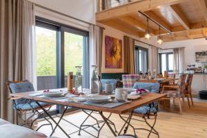 a dining room with a wooden table and chairs at INVITA Natur-Chalets - Gruppenurlaub, Events im Schwarzwald - 6 Apartments, 25 Personen in Bad Dürrheim