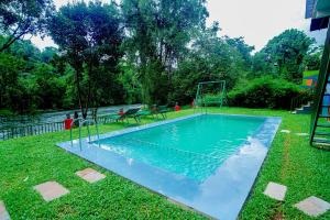 a swimming pool in the grass with a goal at Falcon Riverview Resorts in Kuttampuzha