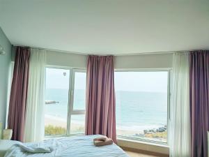 a bedroom with a large window with a view of the ocean at Apartment Sunrise Pomorie in Pomorie