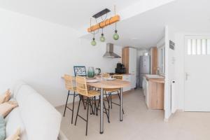 kuchnia i jadalnia ze stołem i krzesłami w obiekcie VILLA BORD DE MER 6 COUCHAGES AVEC JARDIN ET GARAGE w mieście La Grande-Motte