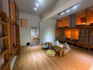 un soggiorno con panca, tavolo e scaffali di 蘭嶼愛樂客 Ai Le Ke hostel a Yeh-yin