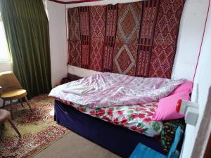 Cama pequeña en habitación con silla en Dede Sebo Çay Bahçesi + Camping, en Doğubayazıt