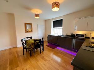 a kitchen and dining room with a table and chairs at Spilman Hotel Apartments in Carmarthen +7 photos