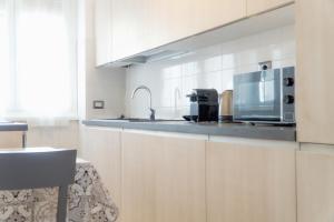 a kitchen with white cabinets and a microwave at A casa di Pina - Roma St Peter in Rome