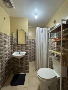 a bathroom with a white toilet and a sink at Babak Point Inland Resort - Exclusive Home with Pool in Samal in Babak