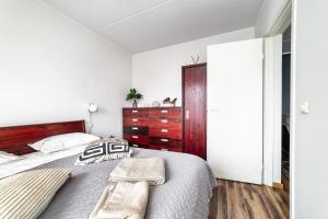a white bedroom with a large bed and a wooden dresser at Top floor near ferry terminal - free parking in Tallinn +18 photos