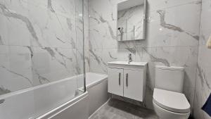a white bathroom with a toilet and a sink at Camden Market Properties in London +82 photos