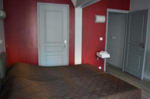 a bedroom with a bed and a red wall at Hôtel Allety in Paris