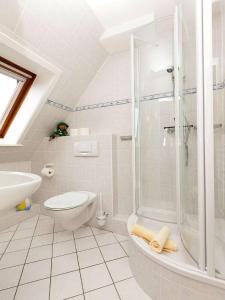 a white bathroom with a shower and a toilet at Haus Seeflieger in Westerland +44 photos
