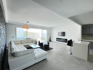 a white living room with a couch and a table at Meditranee Sea View in Tangier