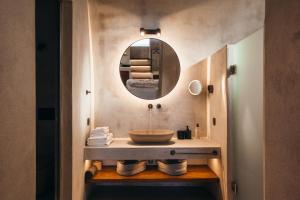 a bathroom with a sink and a mirror at Aethra Vegan Caves in Pyrgos +60 photos