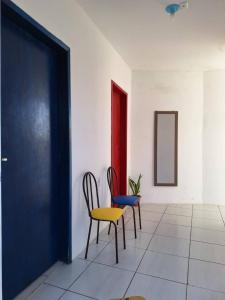 two chairs and a table in a room at Quarto Up perto do Centro e de Praias in São Luís