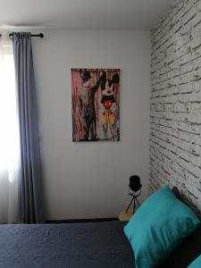 a bedroom with a bed and a painting on the wall at La maison de 6Fran appartement 1 calme et spacieux ambiance familiale in Valros +21 photos