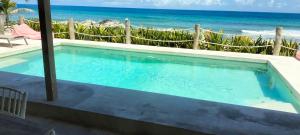 a swimming pool with the ocean in the background at Punta Piedra studios in Isla Mujeres