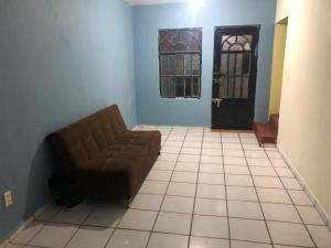 a living room with a couch and a door at Habitacion llena de paz in Tonalá