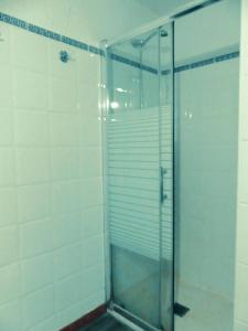 Warung في لاجاريس: دش زجاجي في حمام به بلاط أبيض +42 صورة