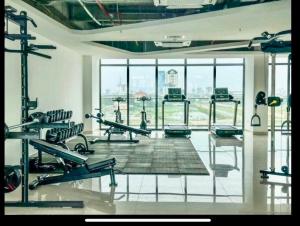 a gym with several tread machines and a large window at Châu Gia homestay in Thôn Văn Dương