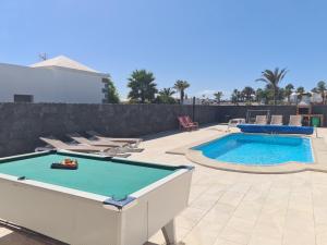 una mesa de billar en un patio junto a una piscina en Villa Carla, en Playa Blanca 43 fotos más