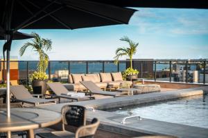 a hotel patio with a pool and tables and chairs at Way Tambaú #A8 - Estúdio confortável por Carpediem in Tambaú