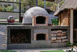 a brick oven with a pile of wood in it at Yolandré in Rustenburg
