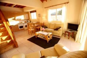 a living room with a couch and a table at Alonia Villas in Pissouri
