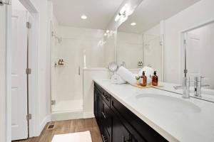 ein weißes Badezimmer mit einem großen Waschbecken und einer Dusche in der Unterkunft Bright & Modern Townhome Near Empower Field! in Denver + 67 Fotos