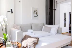 a living room with a white couch and a table at Blueberry Living - Wohlfühl-Apartment Starnberger See, Design, Sport & Natur in Tutzing