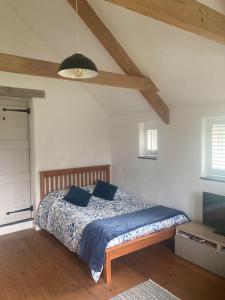 1 dormitorio con cama con sábanas azules y techo en Little Barn, en Bodmin