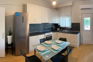 a kitchen with a table and chairs and a refrigerator at Getaway Apartment in Neoi Epivates