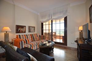 a living room with two couches and a television at Los Pelícanos SOLMARES in Isla Canela