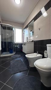 a bathroom with a toilet and a sink and a shower at Dona's Home in Shkodër