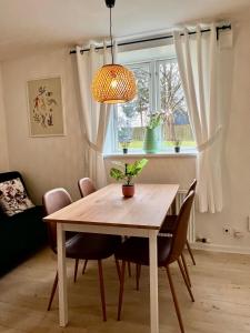 a dining room with a table and chairs and a window at 5 minute walk to LEGO house - 50m2 apartment - unit A - garden on site in Billund